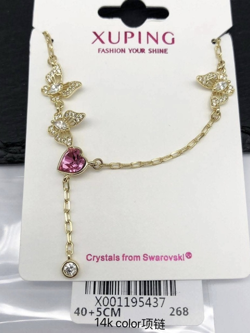 Necklace with butterfly pendants and a pink crystal heart.